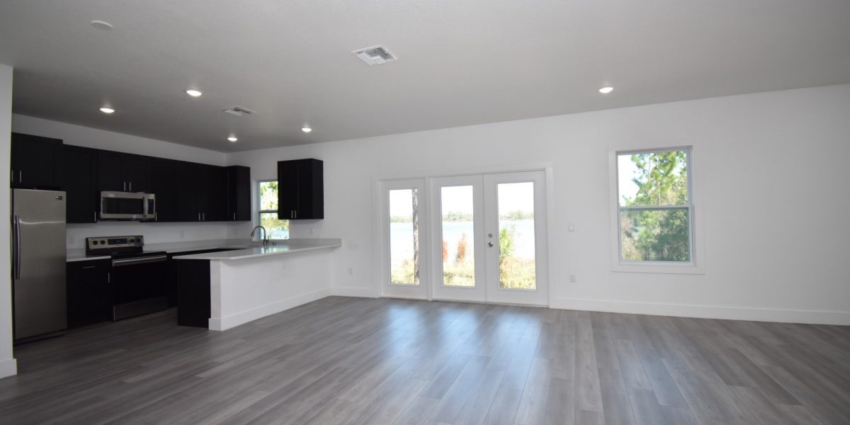 Image of Black Kitchen Cabinets, Double French Doors, White Marble Countertop, and Luxury Vinyl Flooring